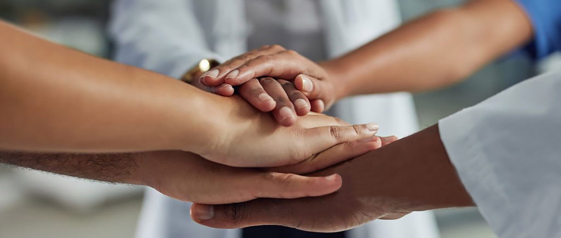 Closeup shot of an unrecognizable group of medical practitioners putting their hands together in a huddle