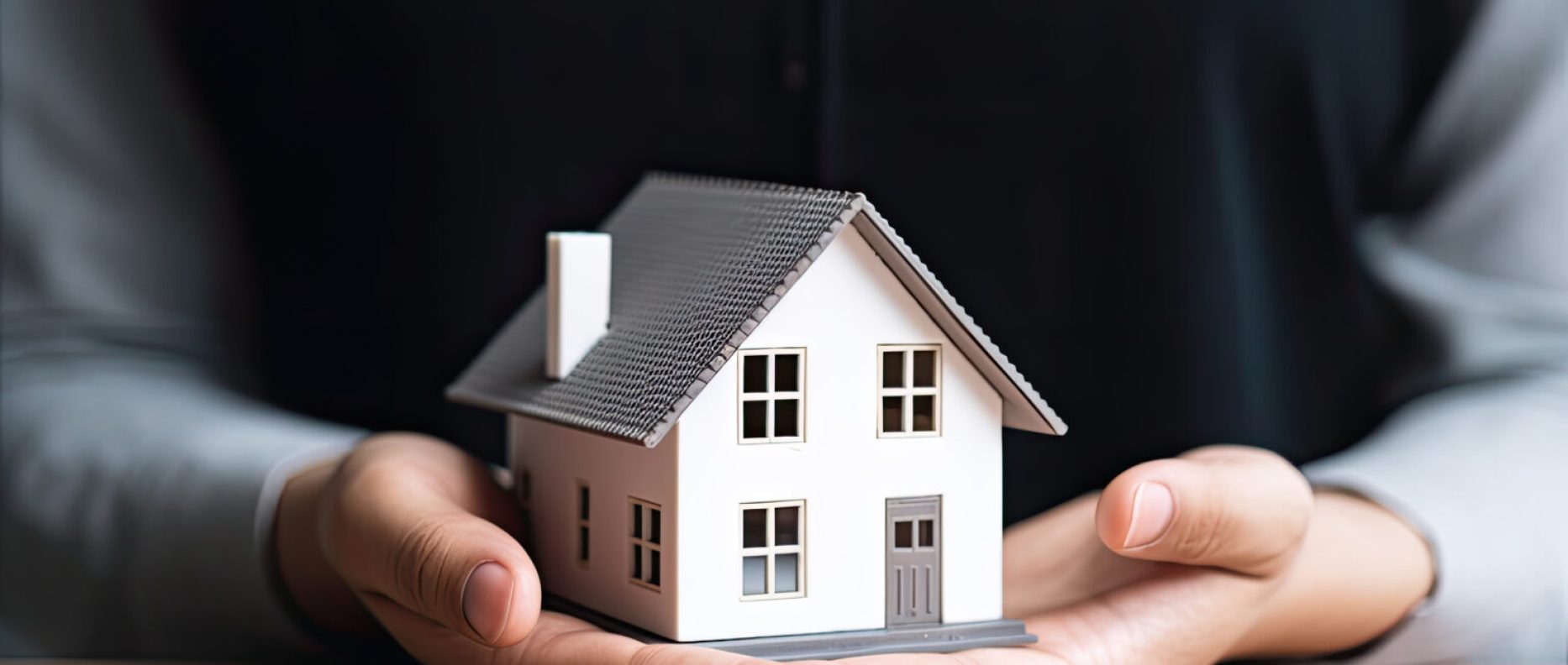 woman showing with one hand a mini house. Real state concept.